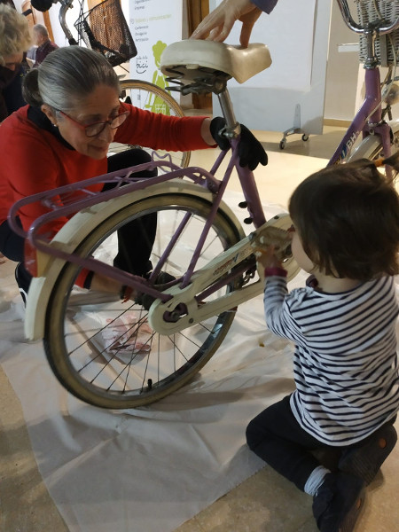 Señora con niña en taller de mantenimiento de bici